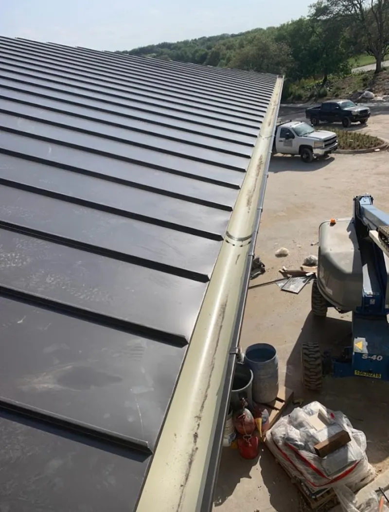Standing seam panel and gutter detail on a metal roofing jobsite in Redding